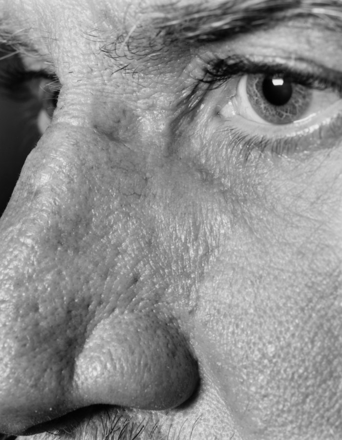Black-and-white close-up photographic portrait of a man's eye and nose