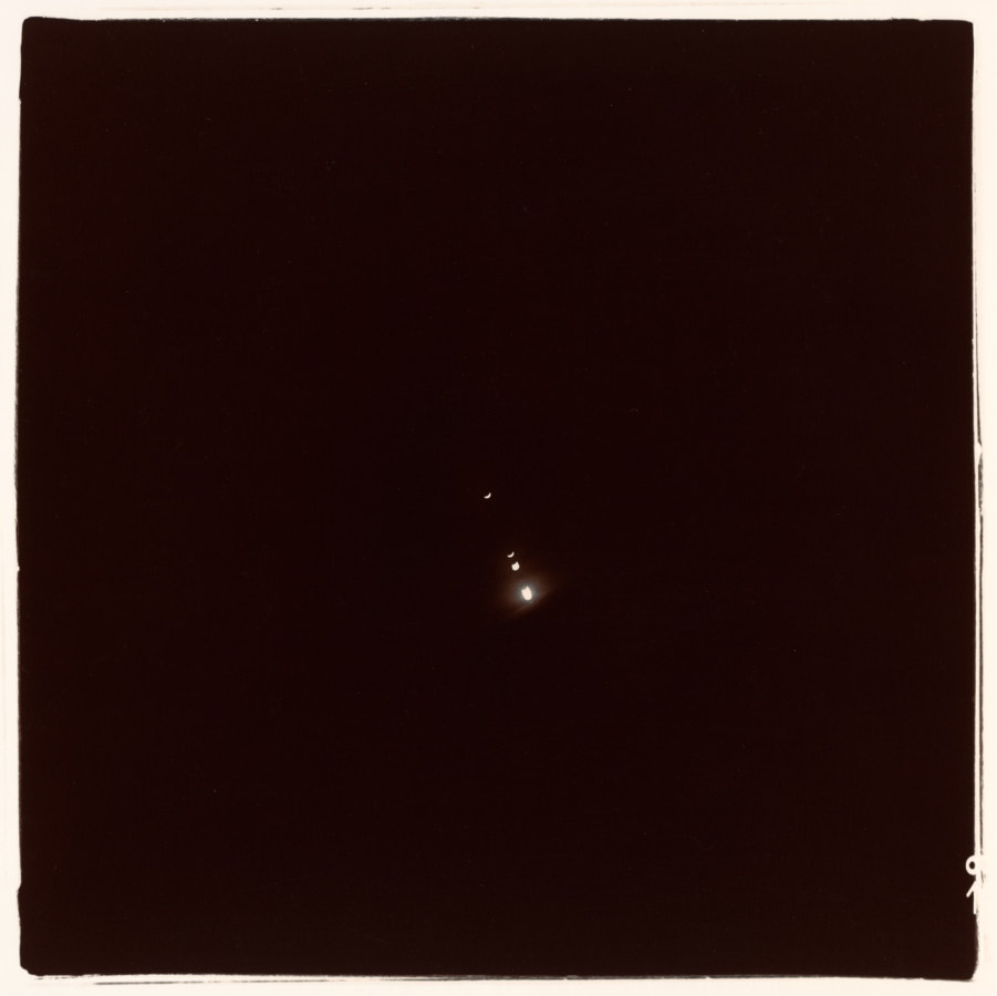 Black-and-white square photograph of a crescent moon and three small light flares