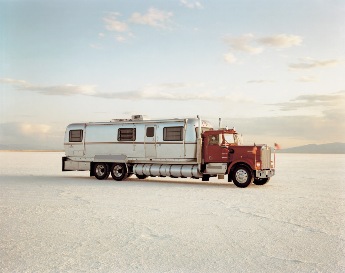 Color photograph of a modified truck pulling a trailer home in the middle of a salt flat