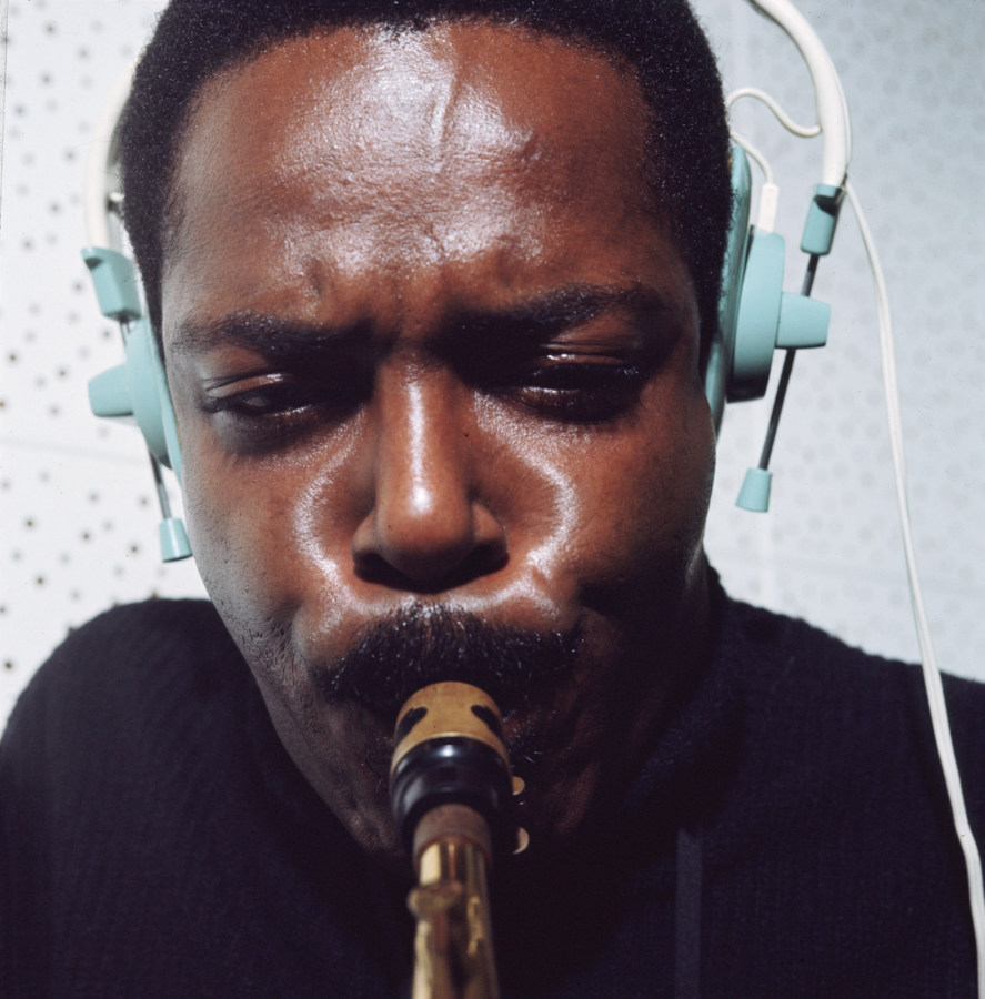 Color photograph up close of a man playing saxophone