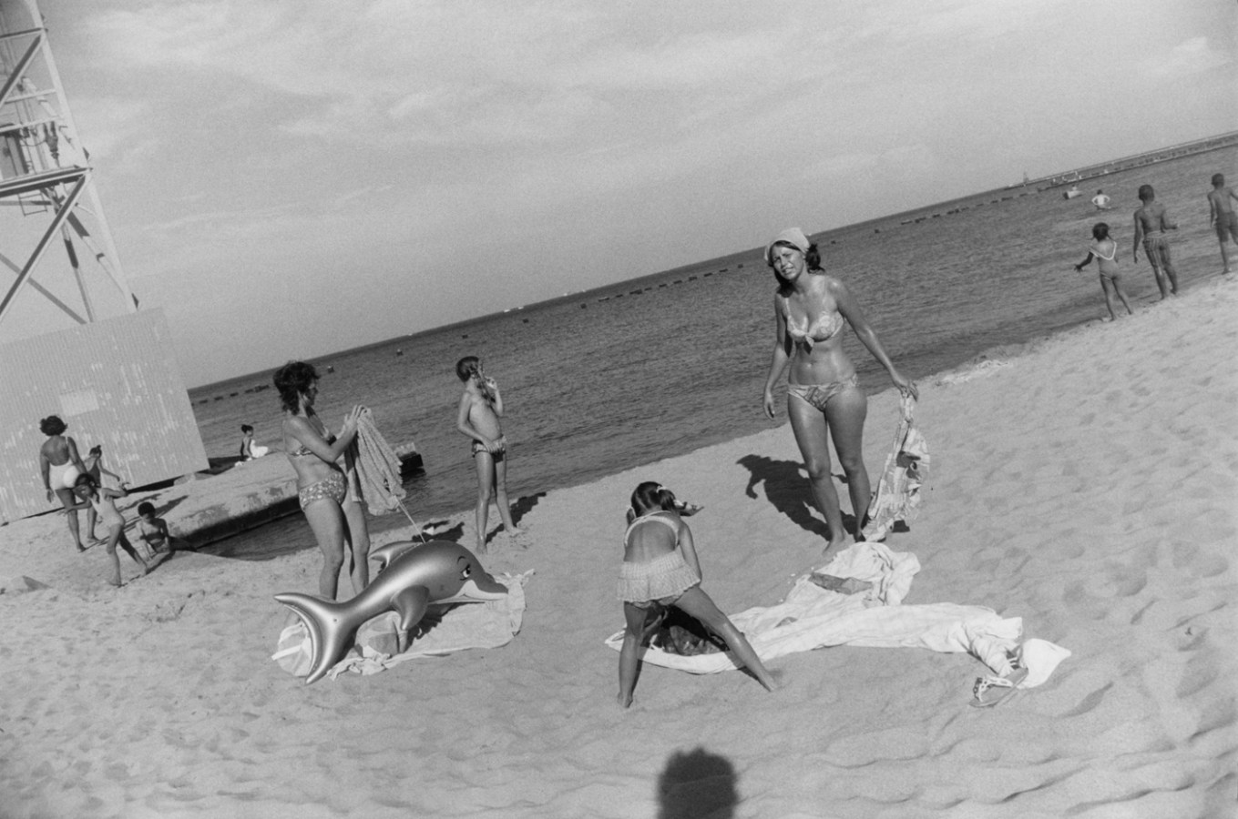 Black-and-white photograph of a group of people in swimsuits on the beach