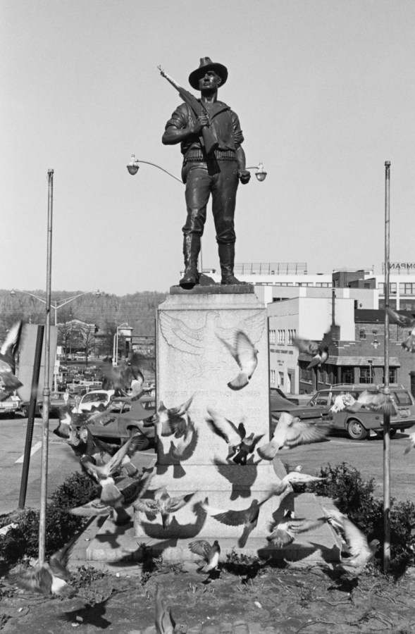 Black and white photograph of a monument surrounded by pigeons