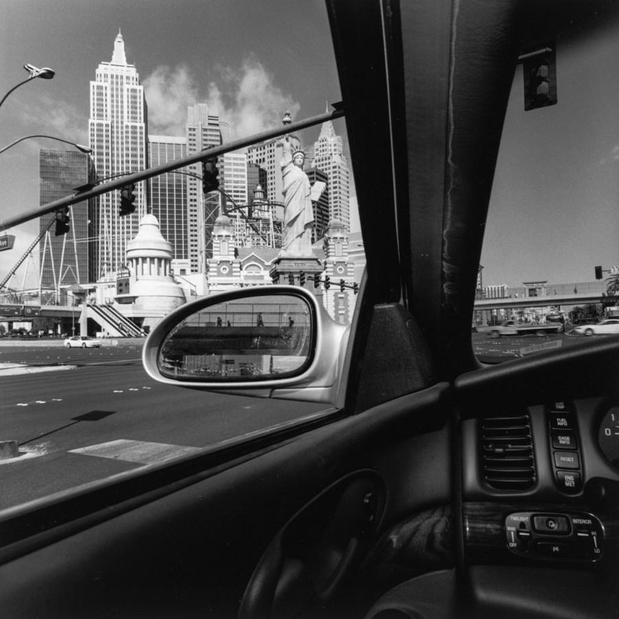 A black and white imaeg of a downtown scene through a car window