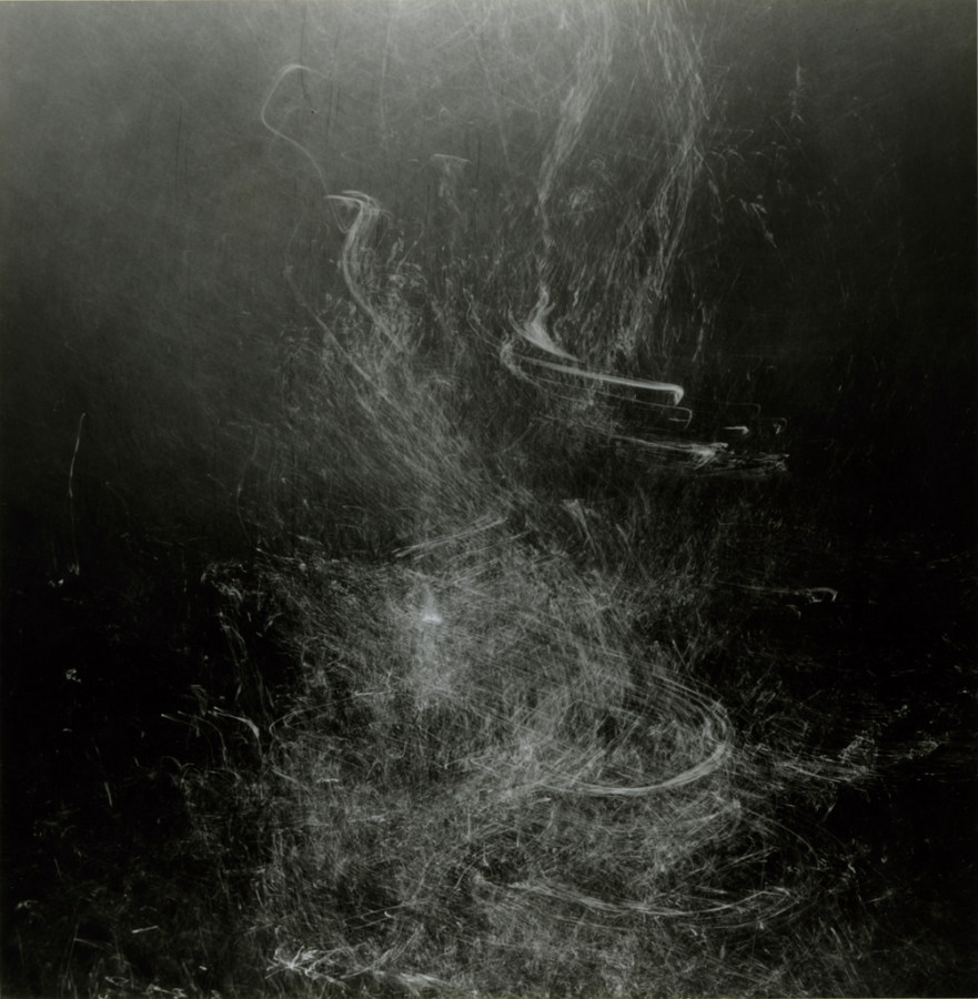 Square black-and-white long-exposure photograph of bubble trails rising underwater
