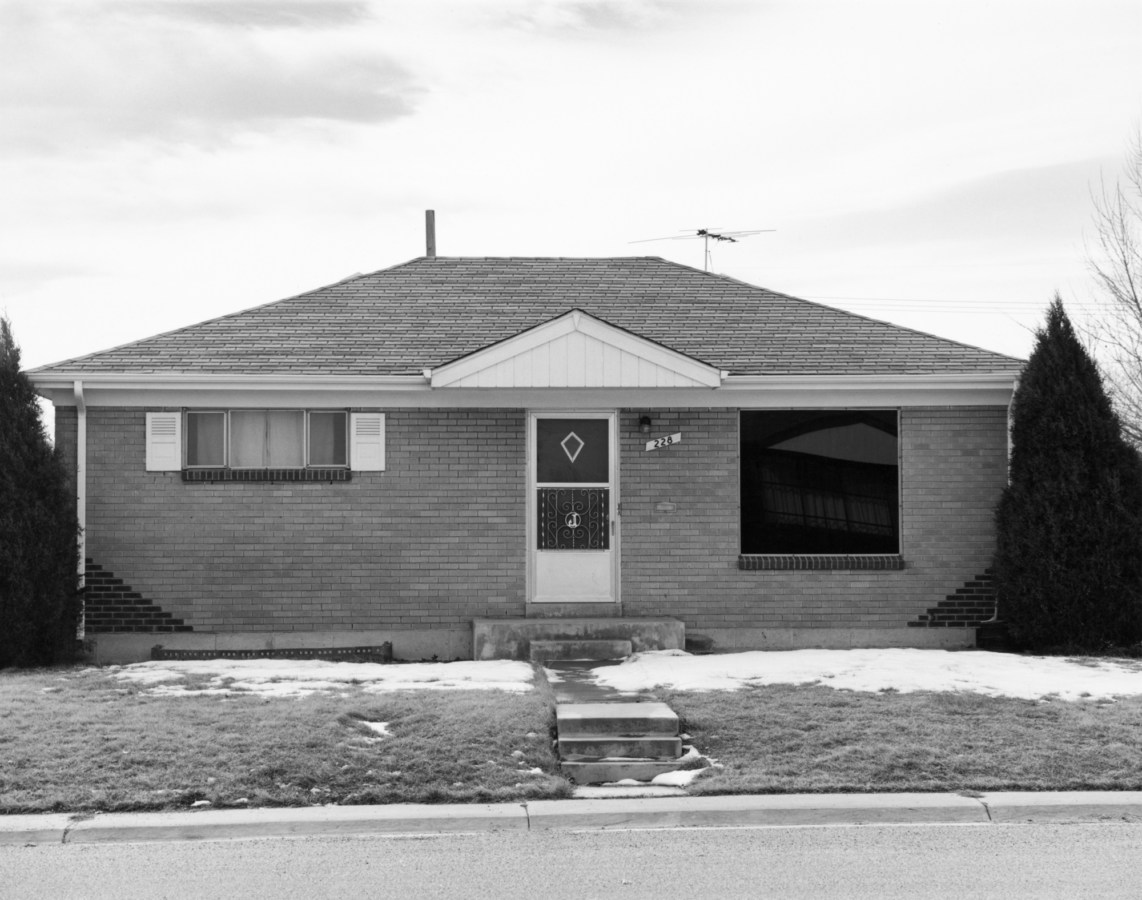 A black and white photograph of a suburban house.