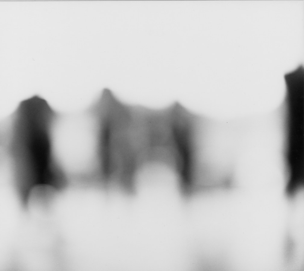Black and white photograph of blurred dark figures