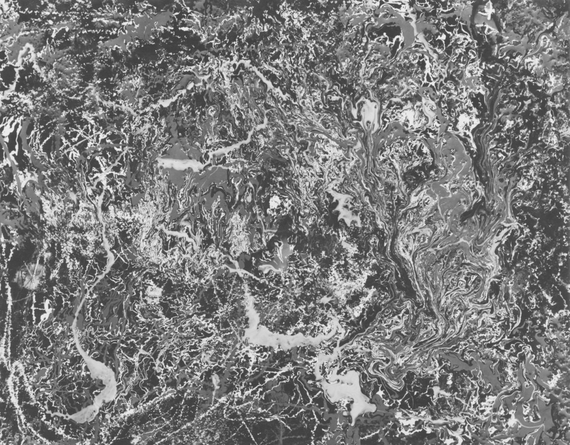 Black-and-white photograph of a foaming, marble-textured liquid surface