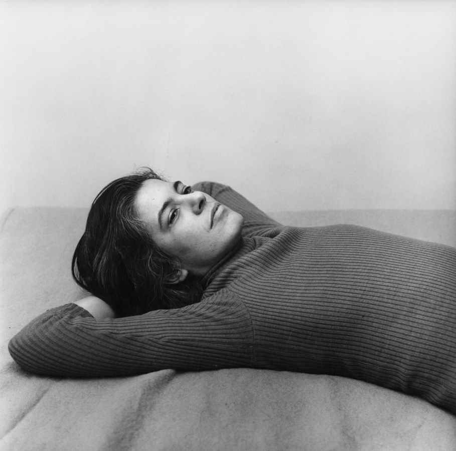 Black and white photograph of woman in turtlneck laying down