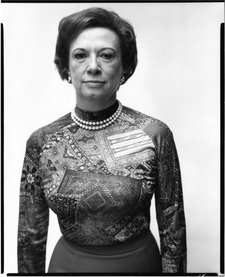 Black and white photograph of a woman wearing a bold-patterned shirt and two small pearl necklaces