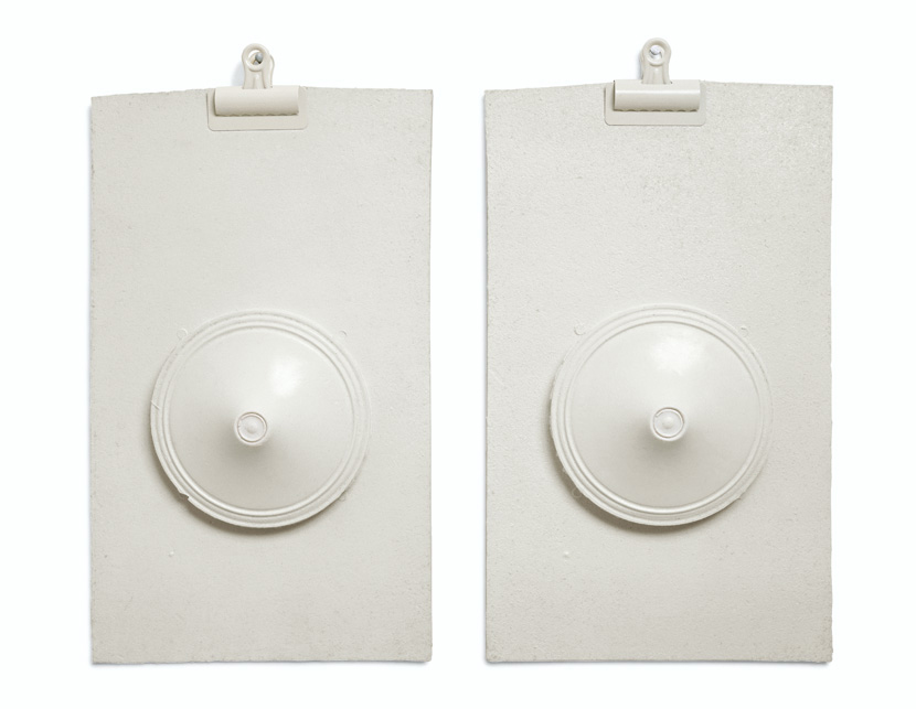 Two all-white sculptures of clipboards with protruding flattened cone forms in the center of each