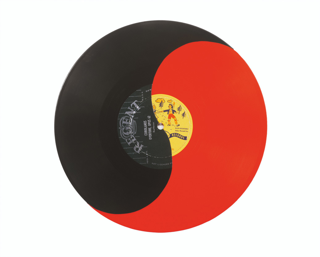 A red vinyl record with half painted black to create a yin-yang motif