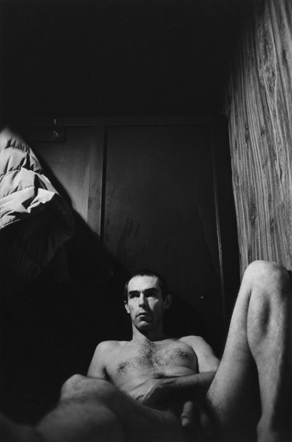 Black and white photograph of nude male laying on ground