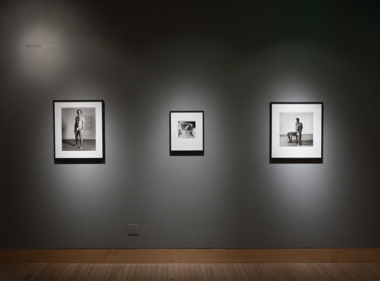 Color image of black and white photographs on grey gallery walls