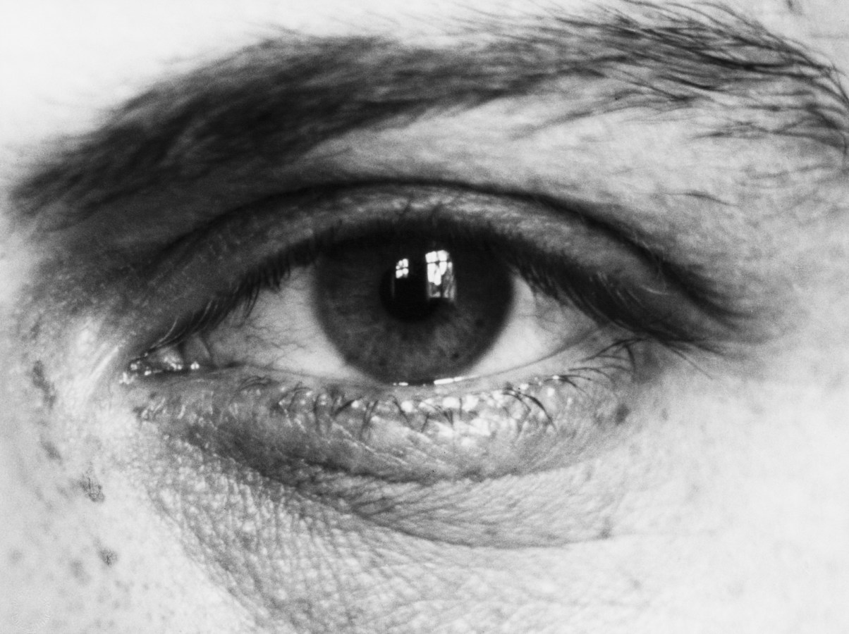 Black and white photograph of a person's eye and eyebrow