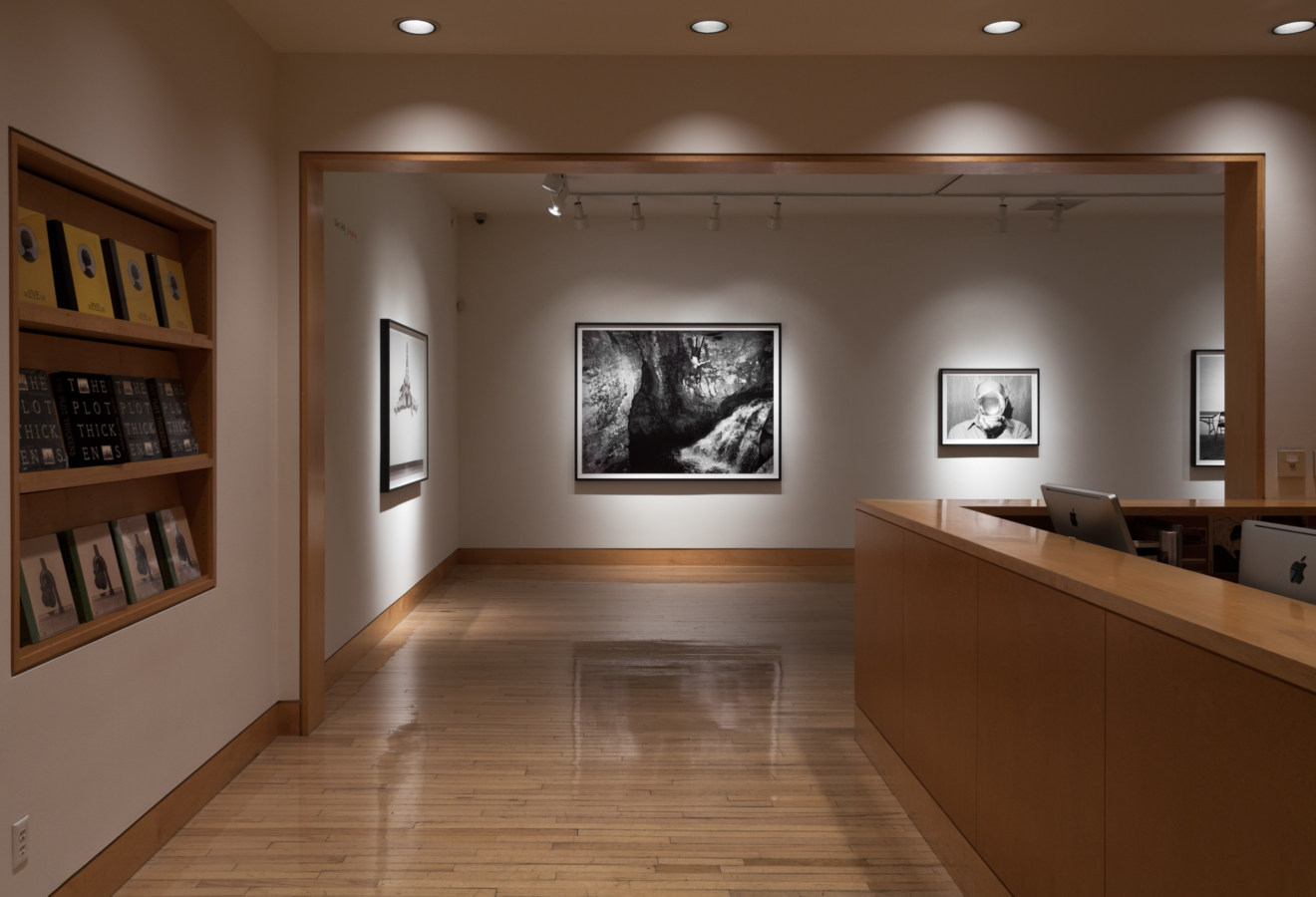 Color image of gallery entryway leading to exhibition of framed black and white photographs
