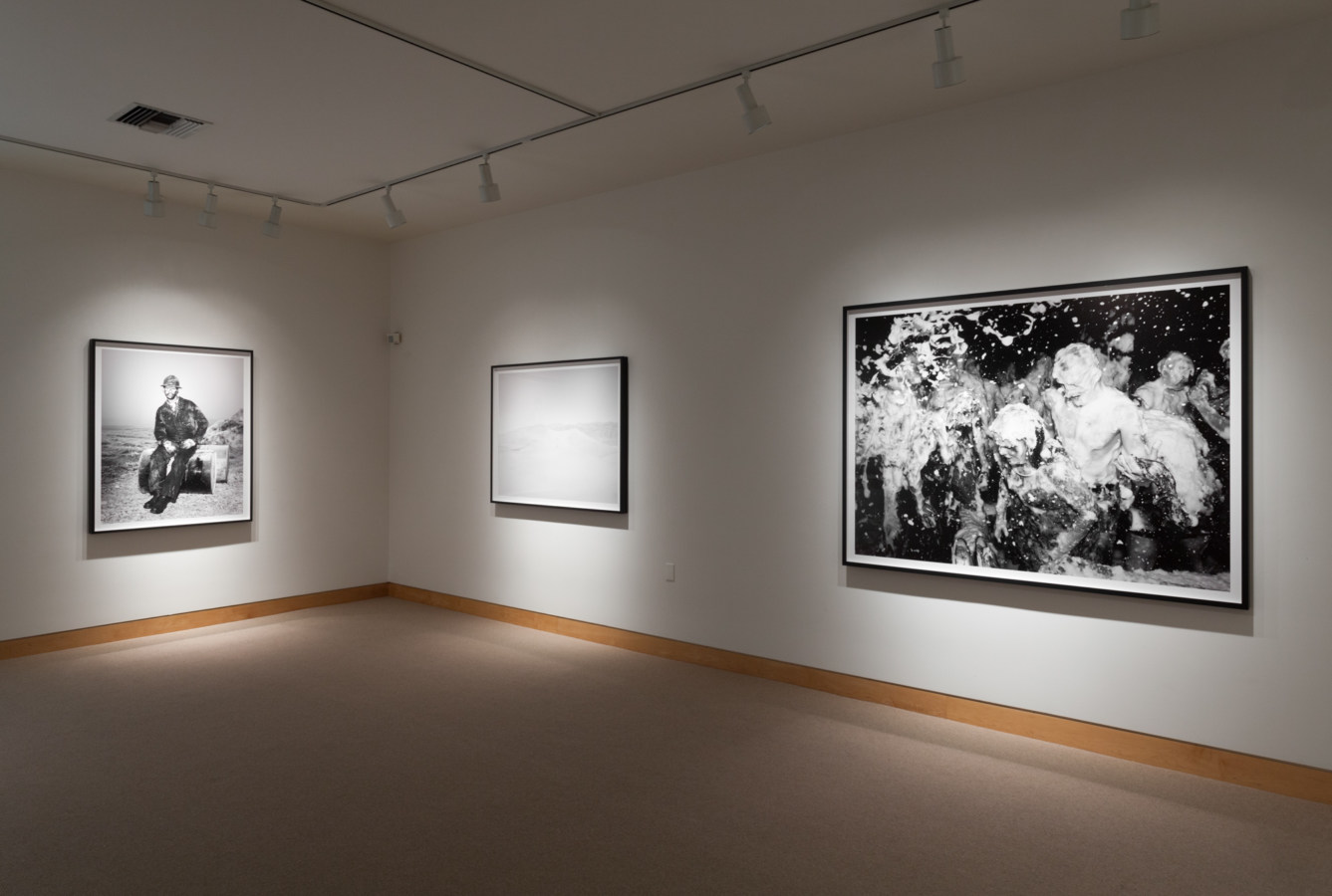 Color image of black and white photographs on white gallery walls