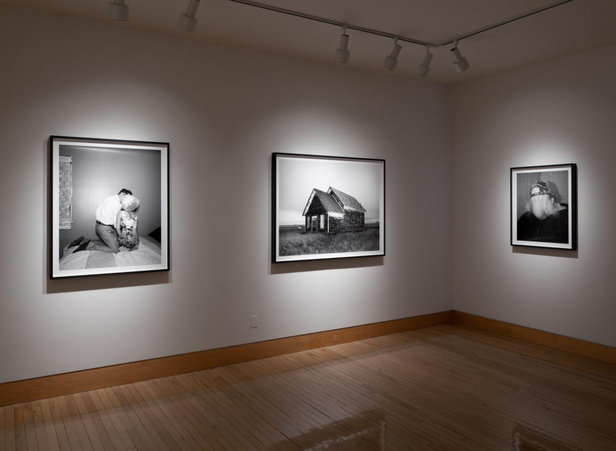 Color image of black and white photographs on white gallery walls