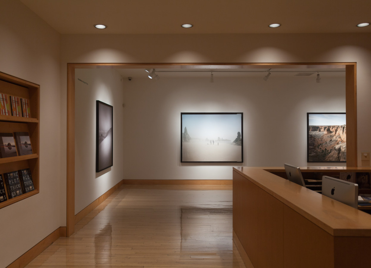 Color image of gallery entryway exhibiting framed large scale color photographs