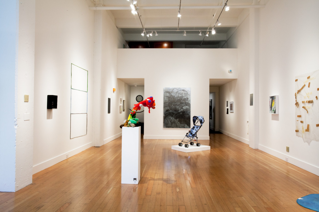 Color image of mixed media and sculptural works on white gallery walls
