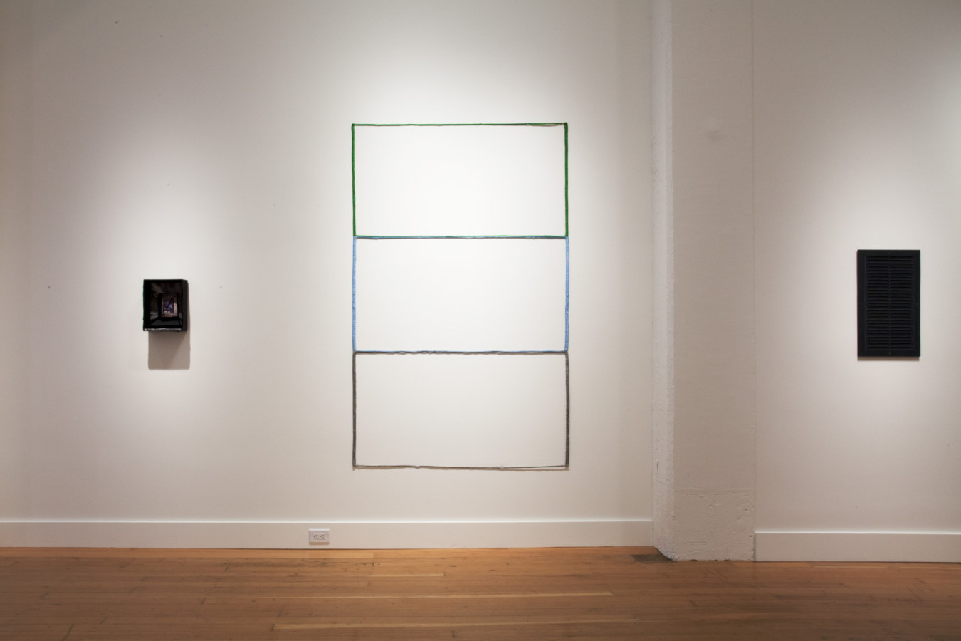 Color image of mixed media and sculptural works on white gallery walls