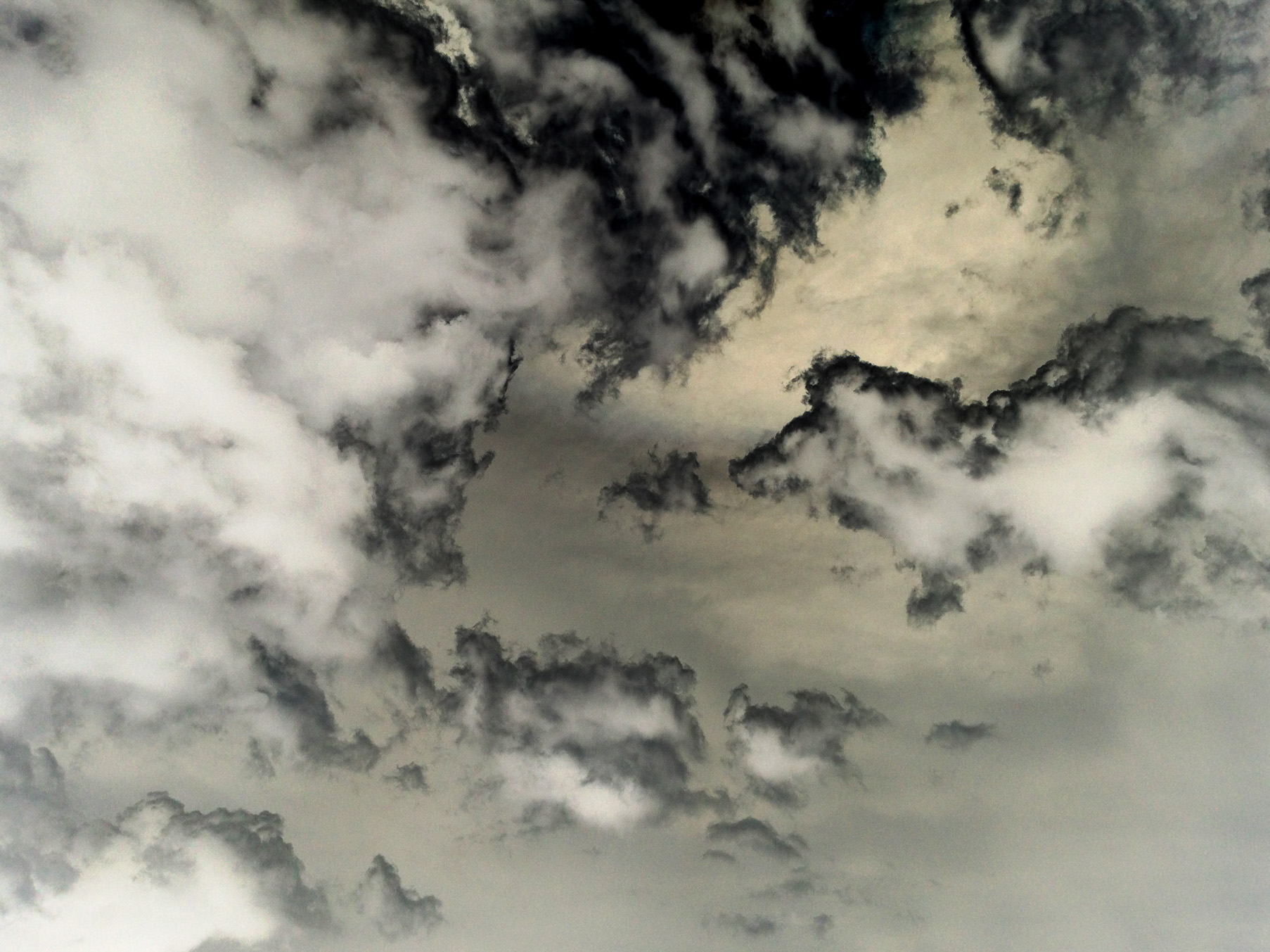 Inverted color photograph of a cloudy sky