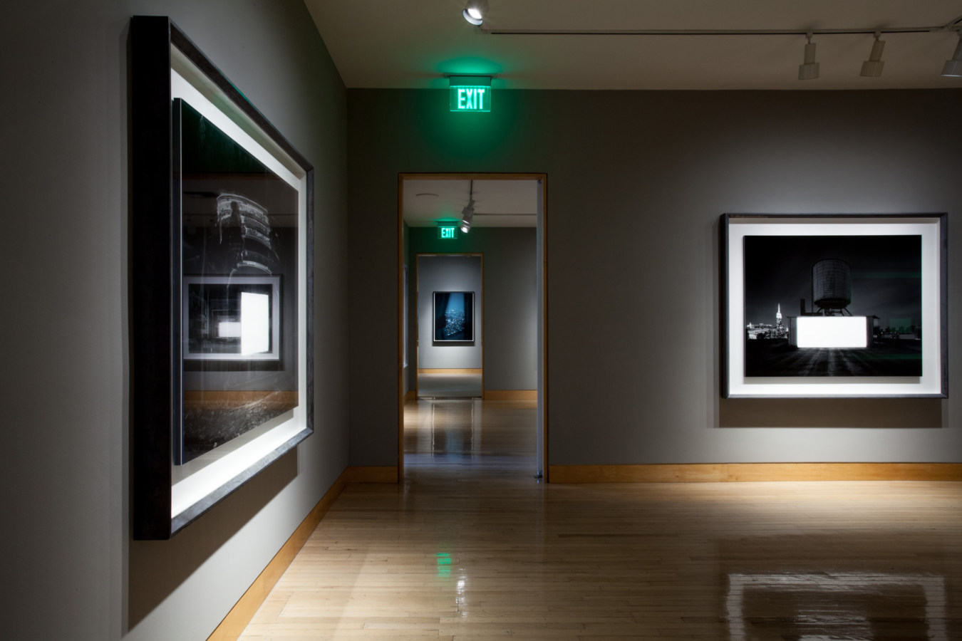 Color image of large scale black and white photographs on grey gallery walls
