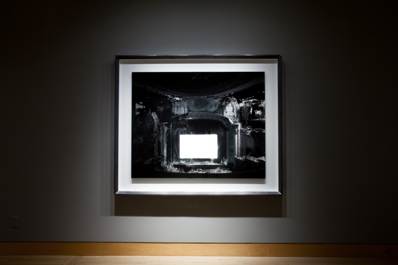 Color image of large scale black and white photograph on grey gallery wall