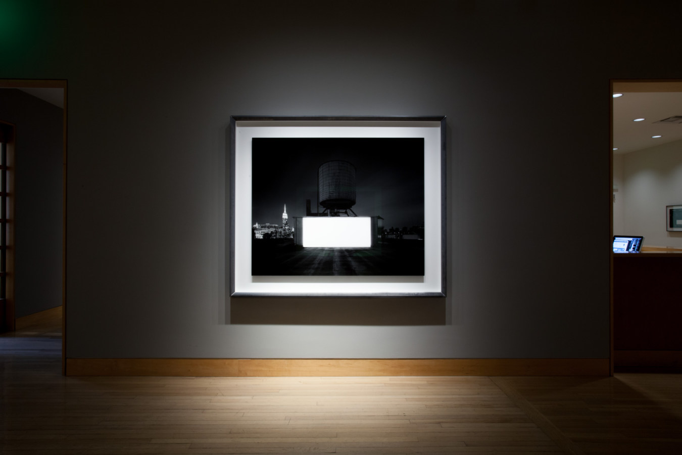 Color image of large scale black and white photograph on grey gallery wall