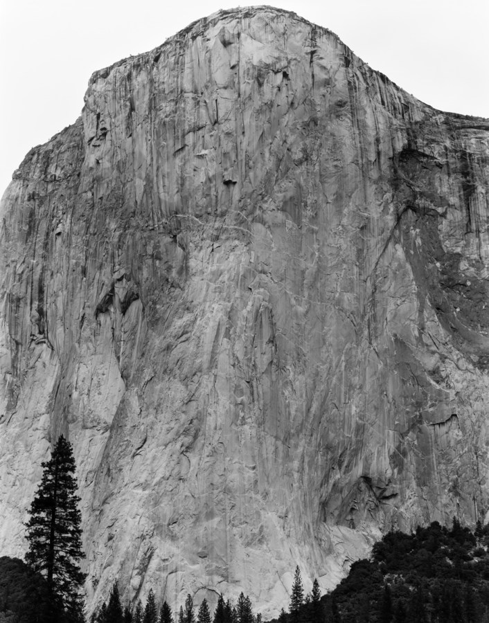 Black and white photograph of mountain side with rock climbers