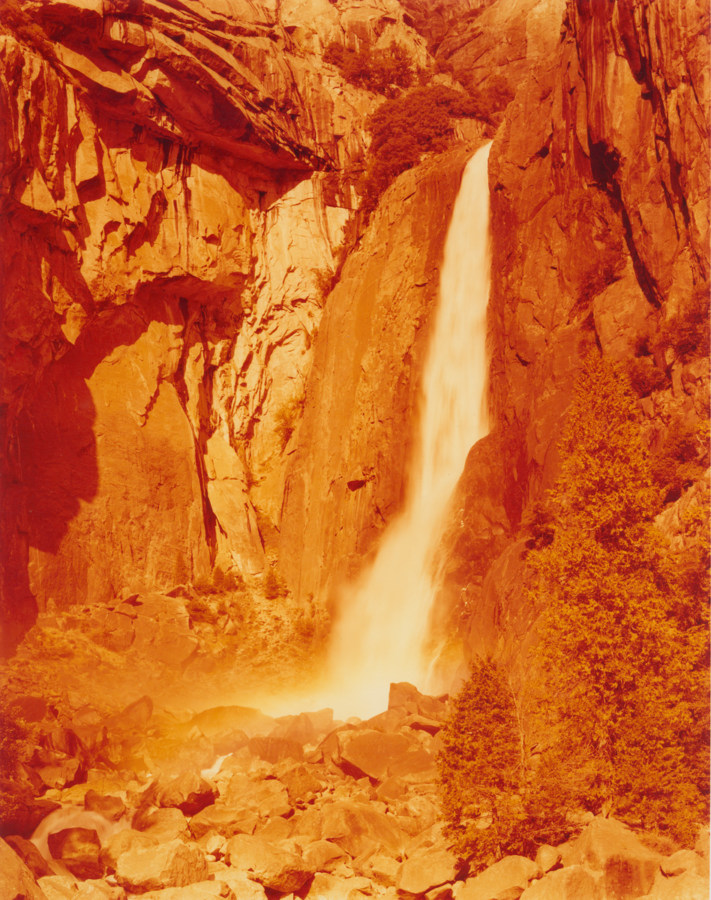 Color photograph of waterfall in an orange hue