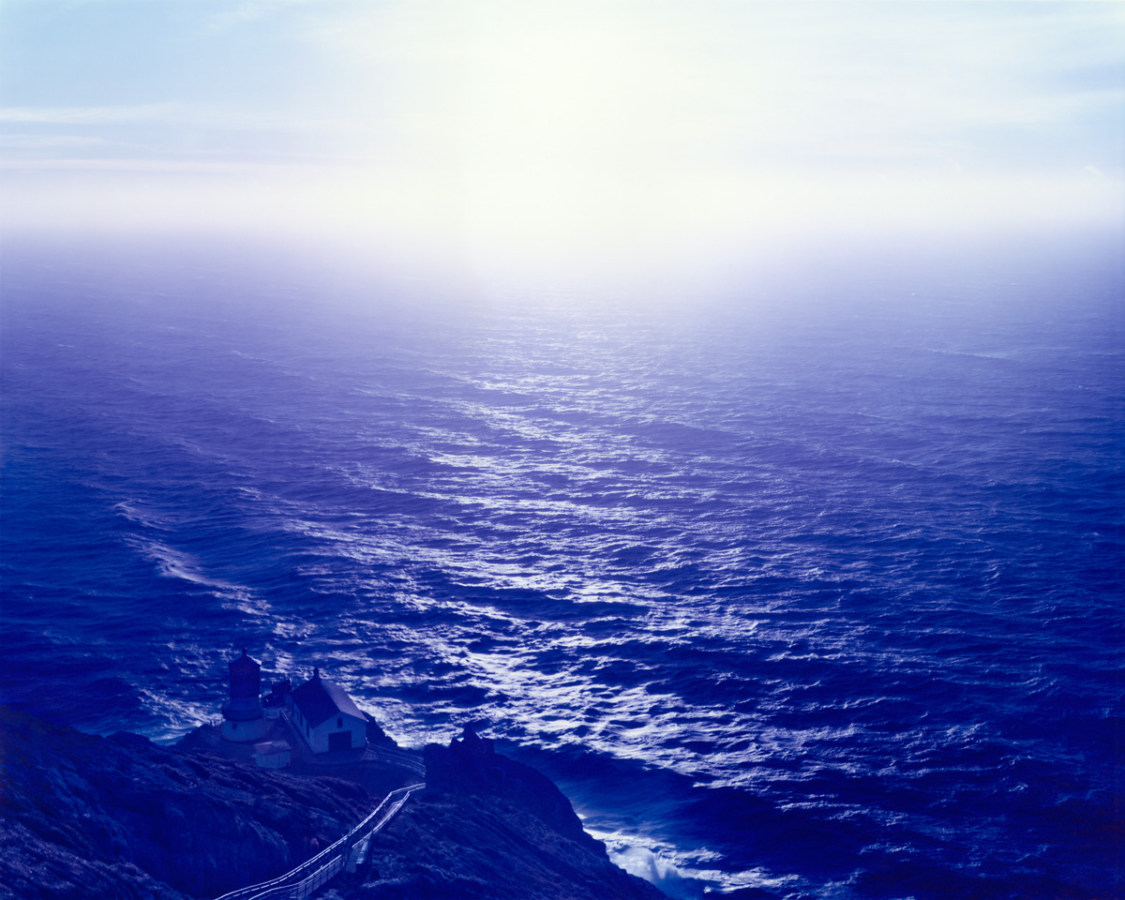 Color photograph of ocean horizon hued in blue