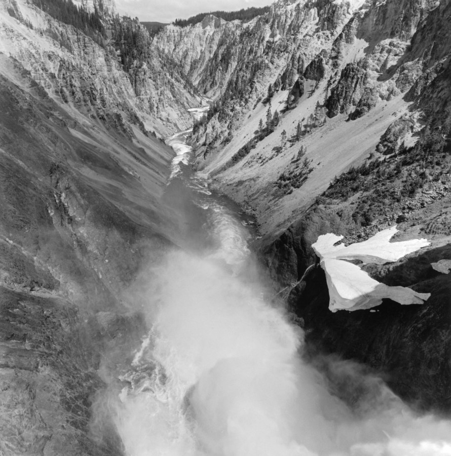 Black and white photograph of mountainous valley with body of water running through