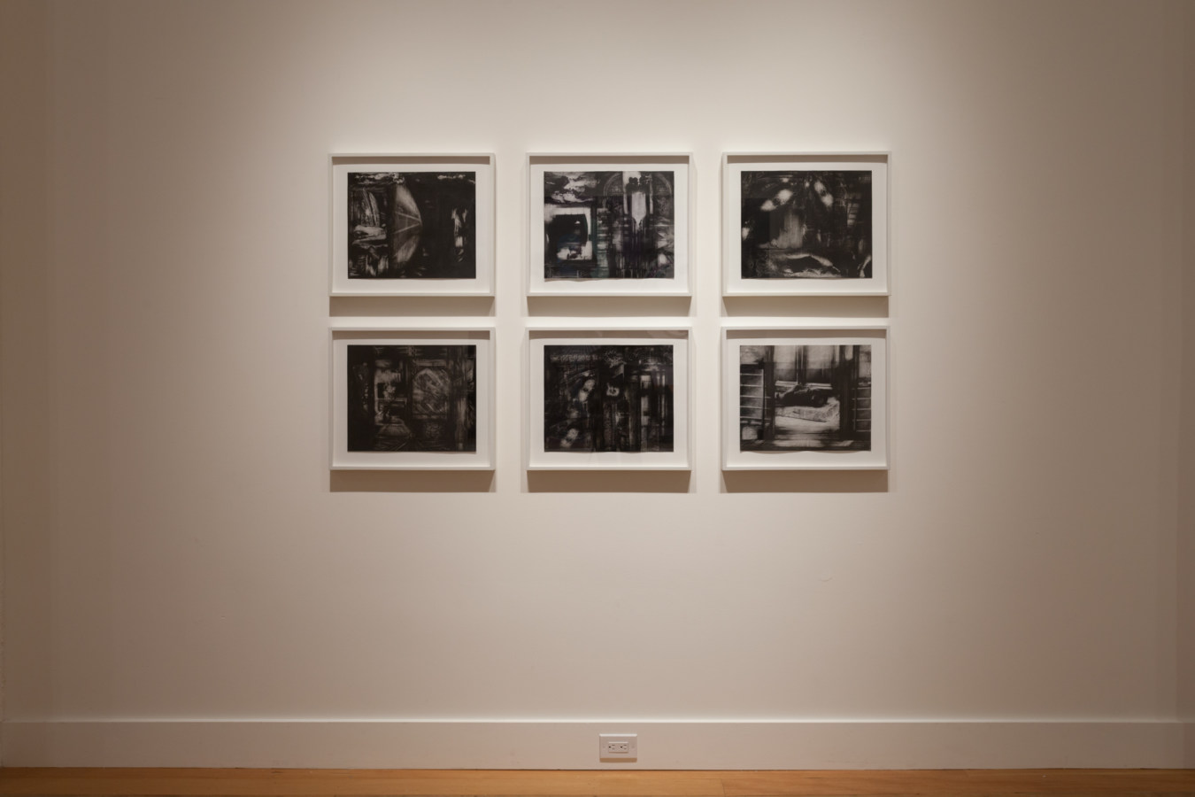 Installation photograph of a gallery space with framed black and white prints on the walls