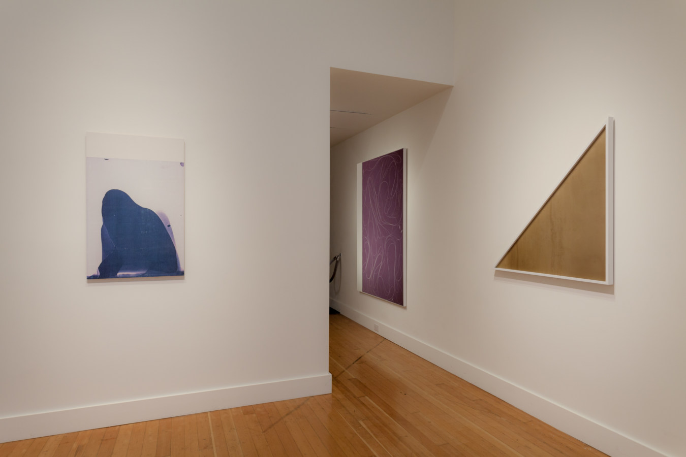 Installation photograph of a gallery space with prints and canvases on the walls