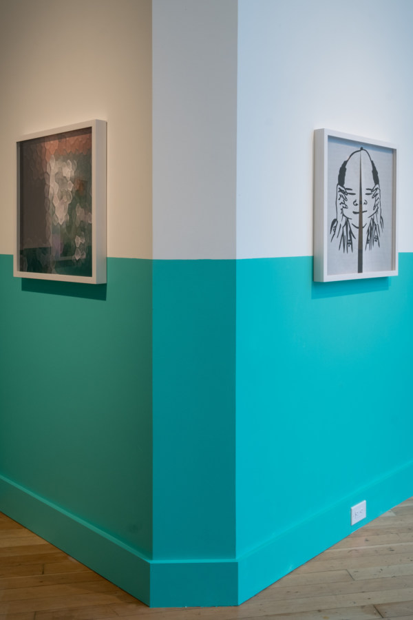 Color image of framed color photographs on white and teal gallery walls