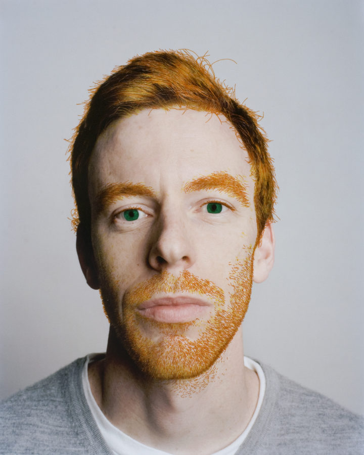 Color photograph of a red haired man with markings extenuating his body and facial hair