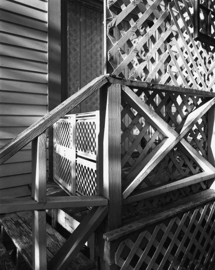 Black-and-white photograph of a latticed screen outside a window