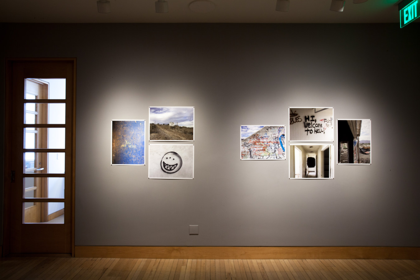 Color image of unframed color photographs on grey gallery walls in different compositions