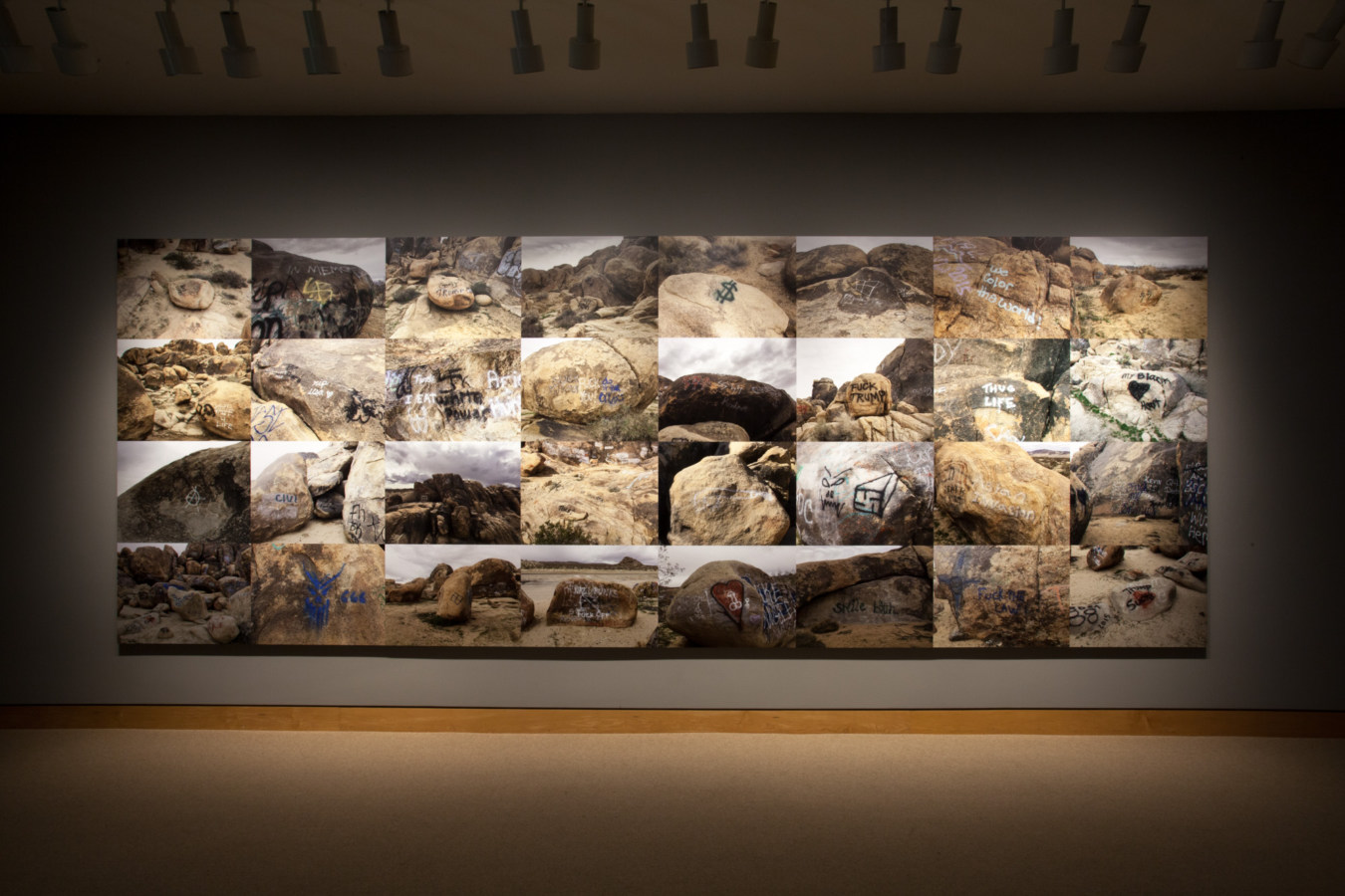 Color image of large scale gridded photographs depicting various graffiti markings on various rocks and boulders