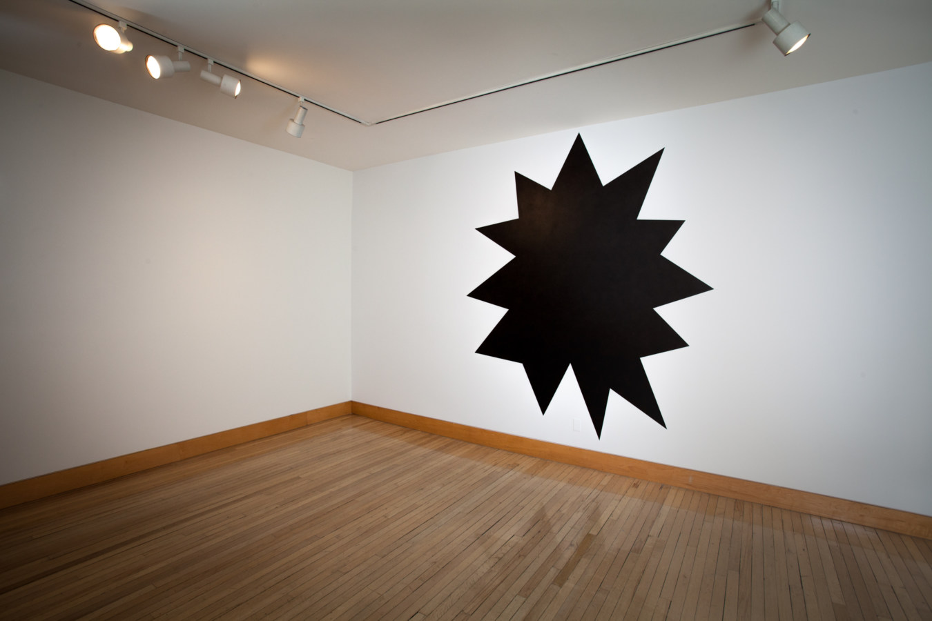 Color image of black geometric like drawing on white gallery wall