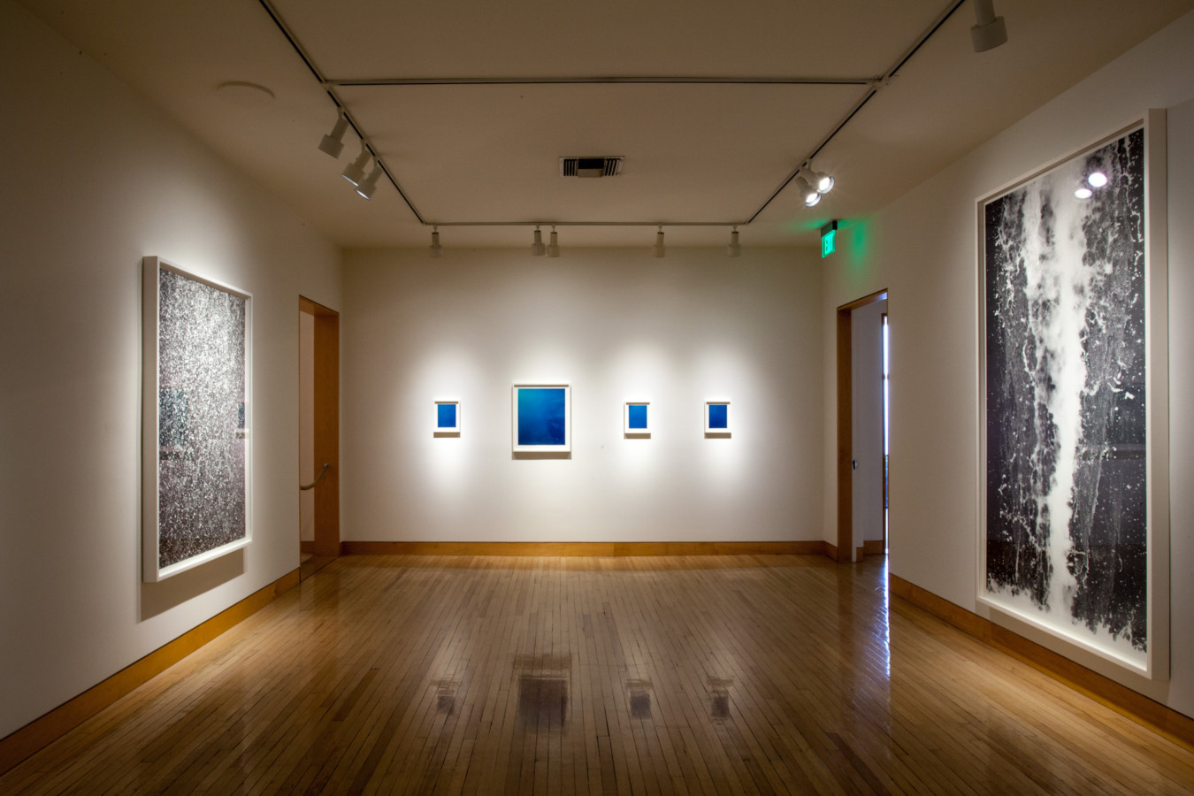 Color image of various sized color photographs on white gallery walls