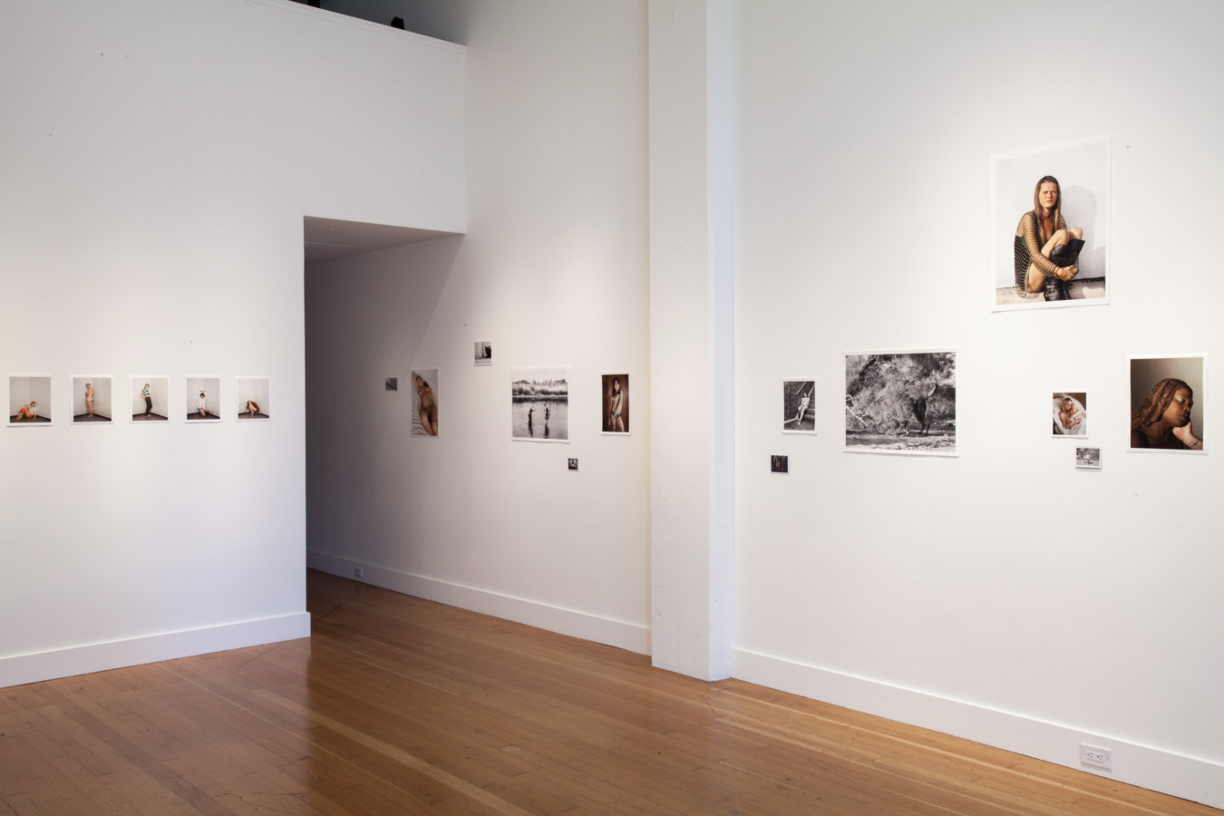 Installation photograph of a gallery space with small unframed prints on the walls