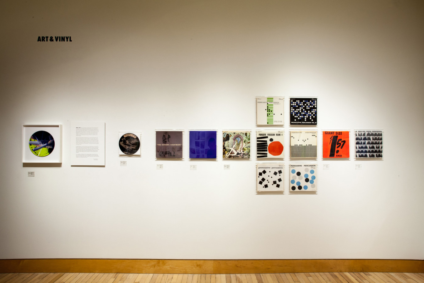 Color image of vinyl records and record sleeves on white gallery wall