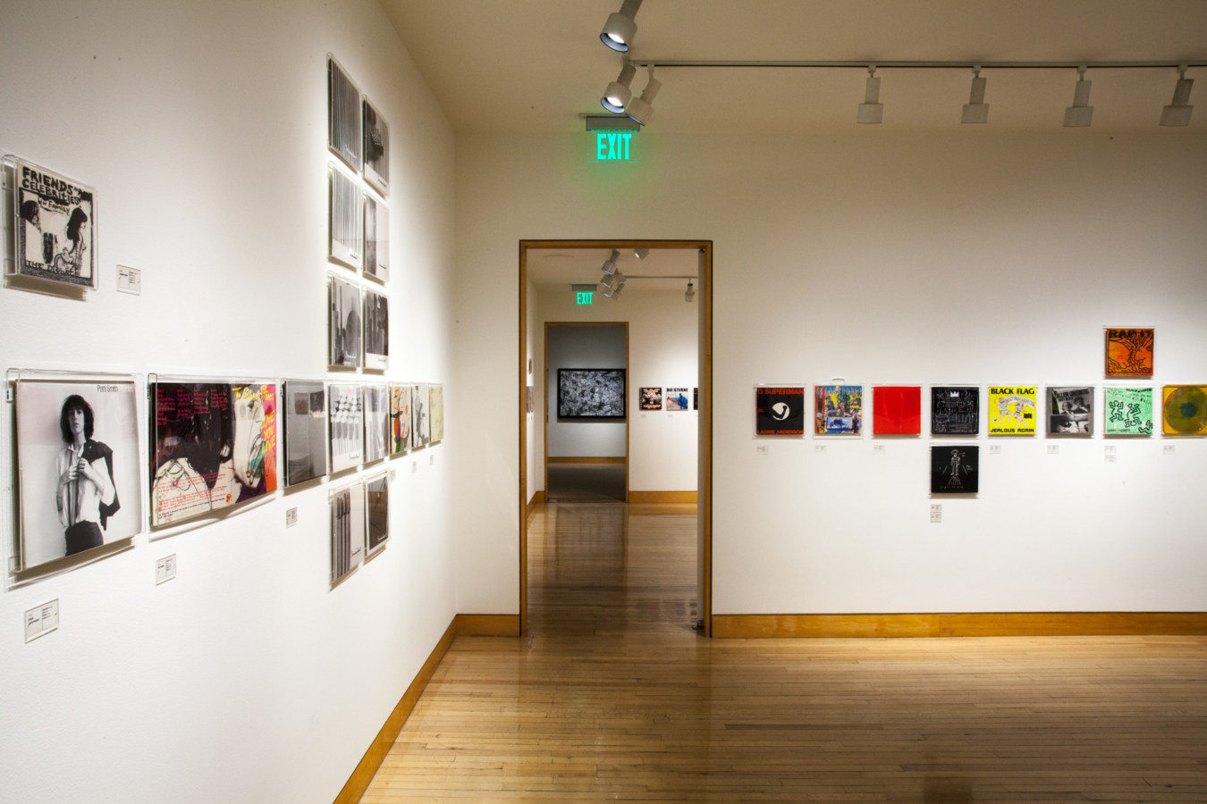 Color image of vinyl records and record sleeves on white gallery walls