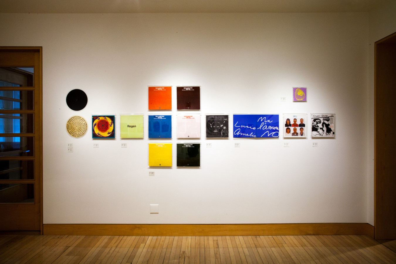 Color image of vinyl records and record sleeves on white gallery walls