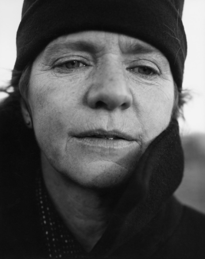Black-and-white photographic portrait of a woman wearing a black hat
