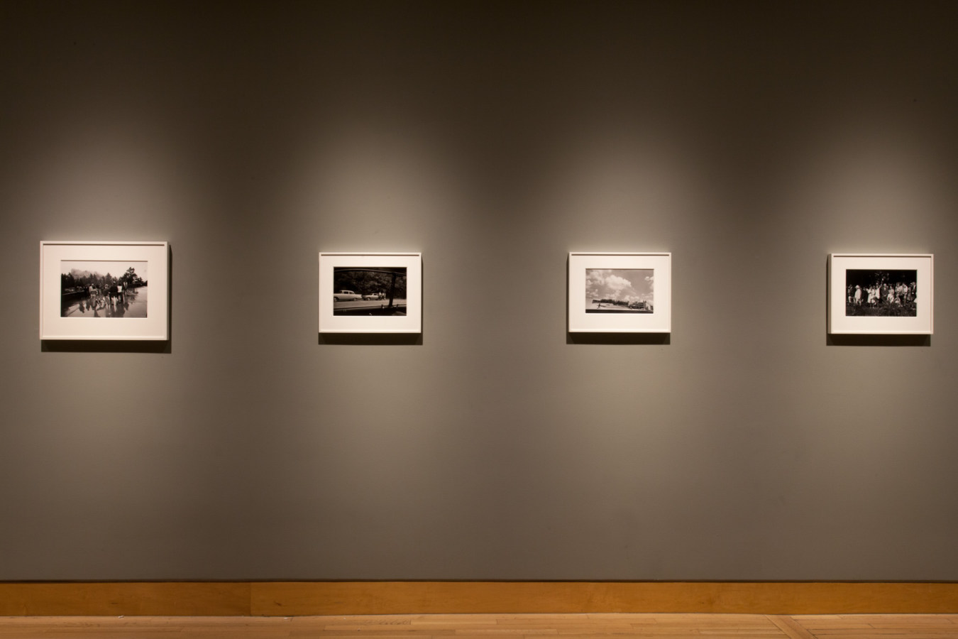 Color image of black and white photographs on grey gallery wall