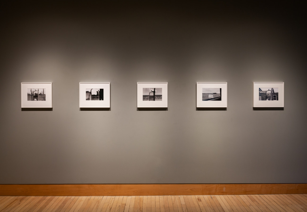 Color image of black and white photographs on grey gallery walls