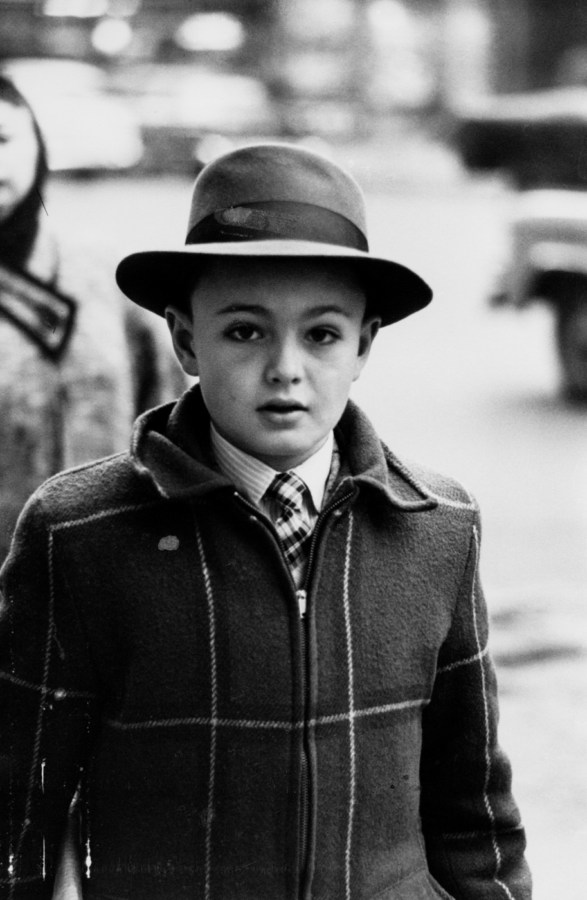 Black-and-white photograph of a boy wearing tie, coat, and hat with full brim