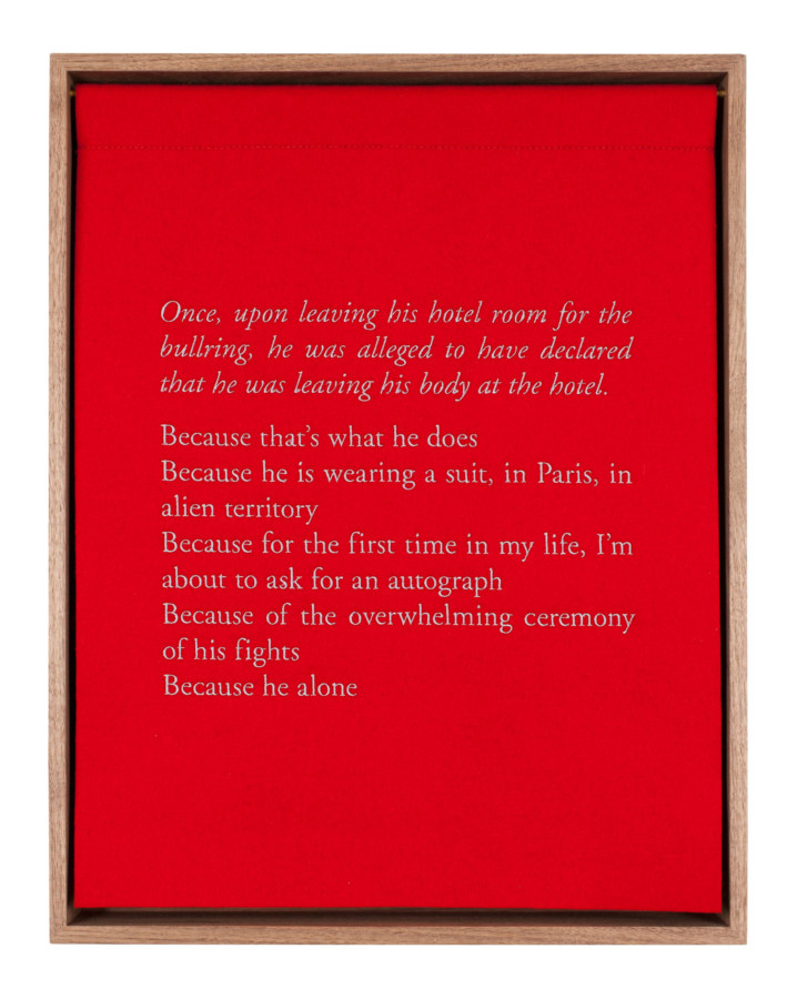 A wooden box with a red curtain, embroidered with white text describing the bullfighter Jose Tomas